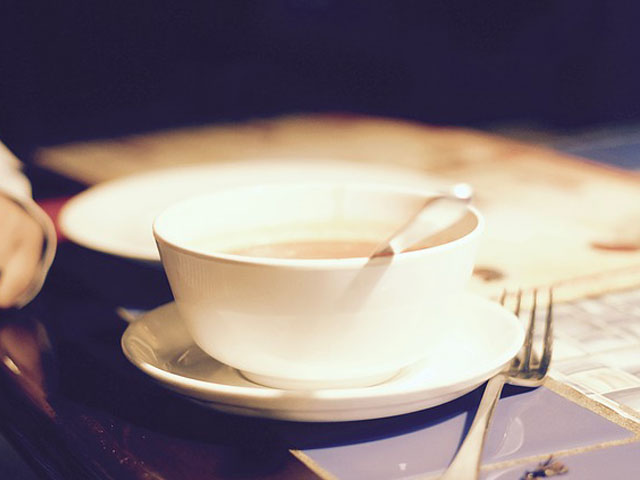 テーブルの上のスープカップとお皿の画像